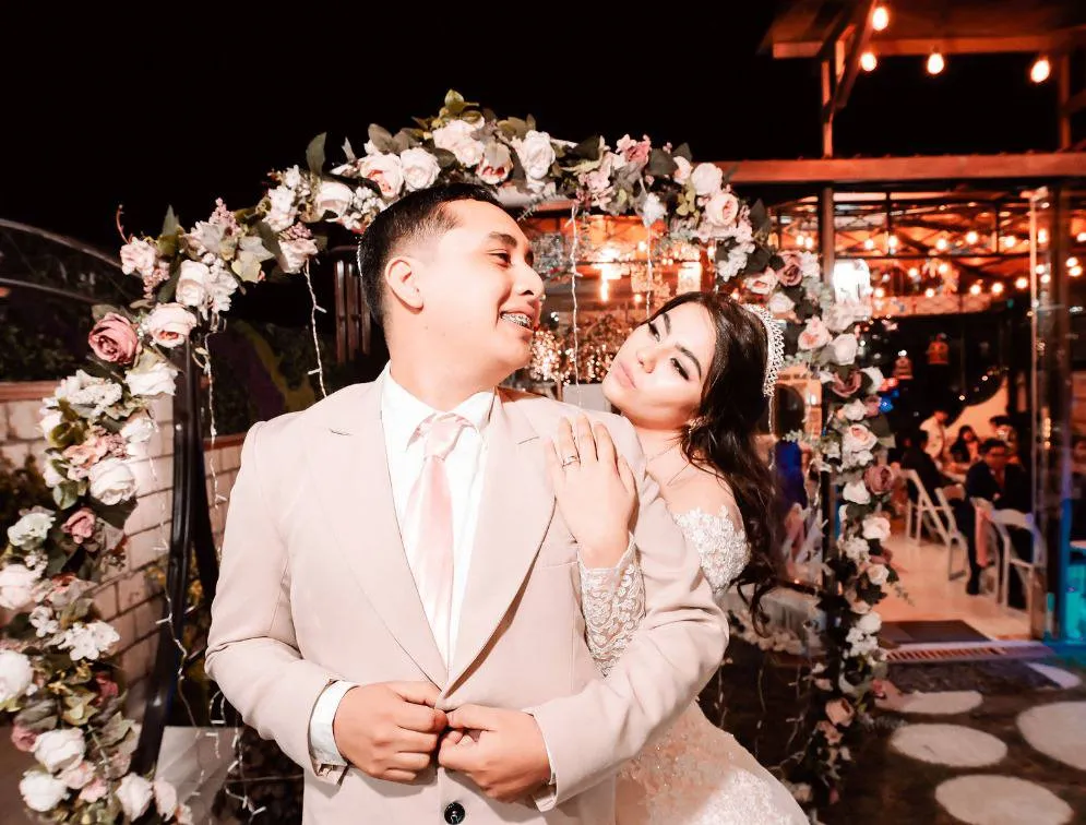 Pareja bajo el arco floral de Salón Colibrí